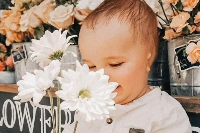 baby-microtia-flowers Baby with microtia smelling large white flowers