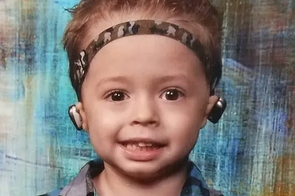 Young boy wearing hearing device