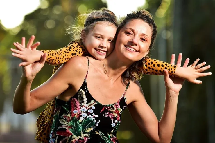 mother-daughter Mother piggybacking daughter with hearing device