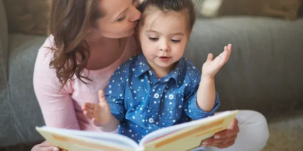 a mother reading a book to a child